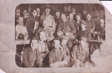 Prisoner of War camp, Meyer is second left, holding the book.
