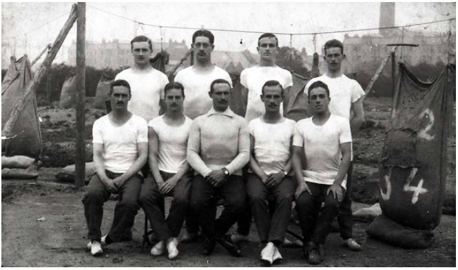 Simeon Salzedo Photo album - Postcard of 'The Fire Eaters' (written in pencil on back) 2nd Sportsman's Batallion, Royal Fusiliers in 1916 (Simeon far right front row)